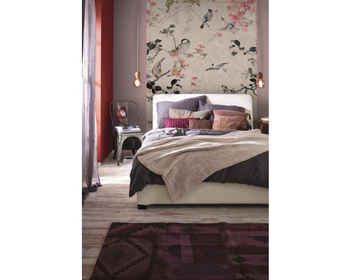 Schlafzimmer mit floraler Tapete, Bett und Teppich