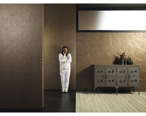 Einrichtungsbeispiel mit Kommode und Mann vor einer Wand mit Tapete