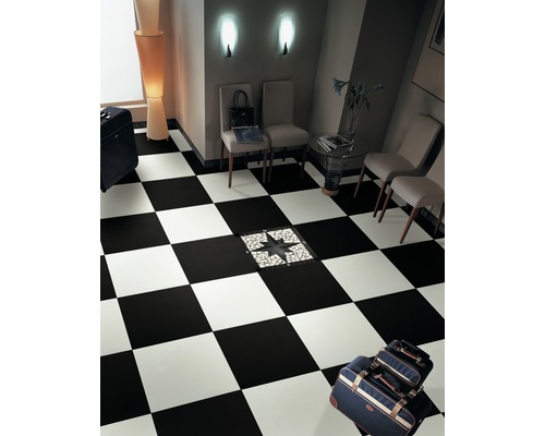 Raum mit Schachbrettmusterfliesen und Wartebereich mit Stühlen und Gepäck
