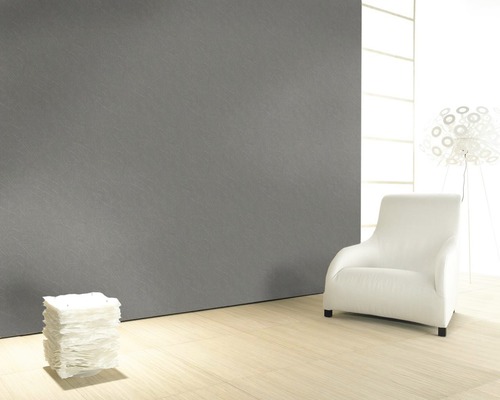 Innenraum mit grauer Wand, hellem Holzboden, Sessel und Lampe