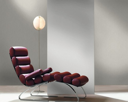 Szene mit einem Liegestuhl mit Rollenpolstern und einer Stehlampe.