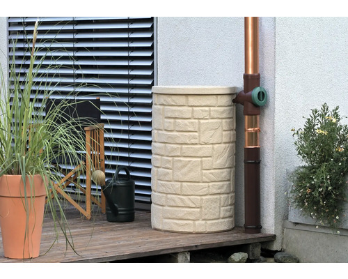 Regentonne in Steinoptik neben einem Fallrohr auf einer Terrasse