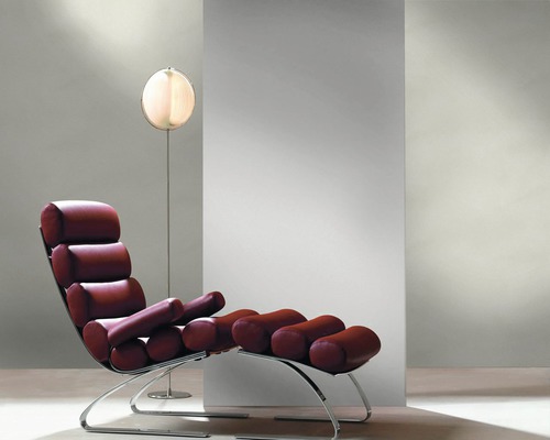 Lounge-Sessel mit verchromtem Gestell und gepolsterten Elementen sowie Stehleuchte
