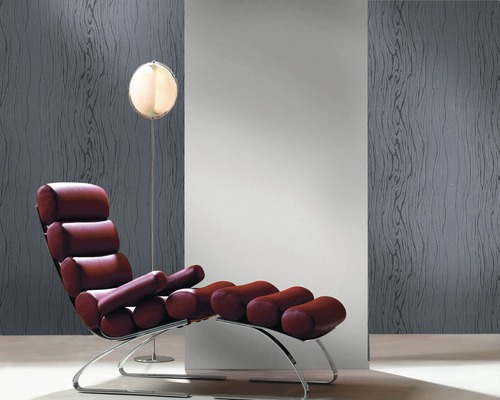 Raumszene mit einem Sessel und einer Stehlampe vor einer Wandtapete mit Holzmaserung