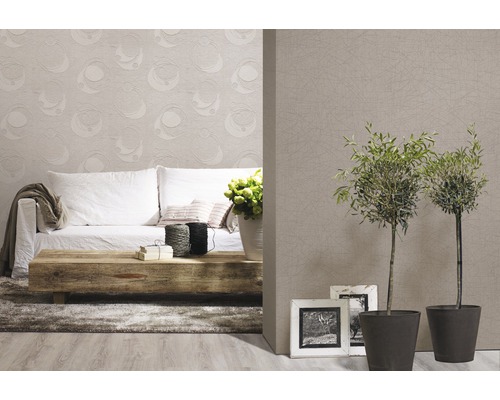 Wohnzimmer mit Sofa, Holztisch, Zimmerpflanzen und gemusterter Tapete