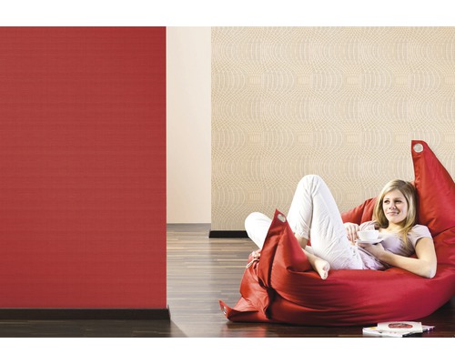 Frau entspannt auf Sitzsack vor roten und beigen gemusterten Tapeten
