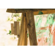 Holzwindspiel hängt an einem Holzrahmen