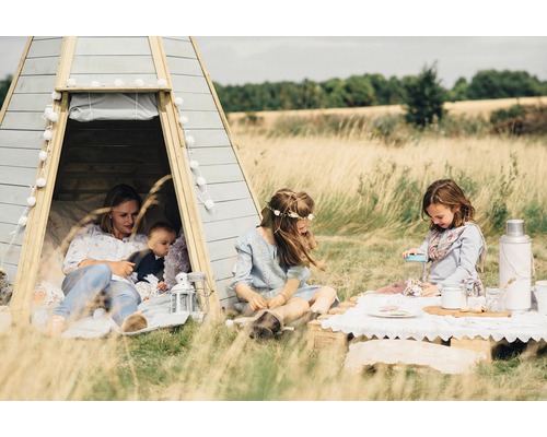 Familie mit Kindern in einem Spielzelt im Freien