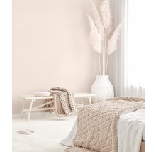 Helles Schlafzimmer mit Bett, Bank, Decken, Kissen und Pampasgras in einer Vase