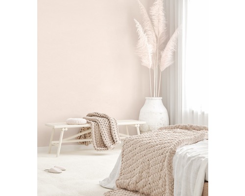 Helles Schlafzimmer mit Bett, Bank, Decken, Kissen und Pampasgras in einer Vase