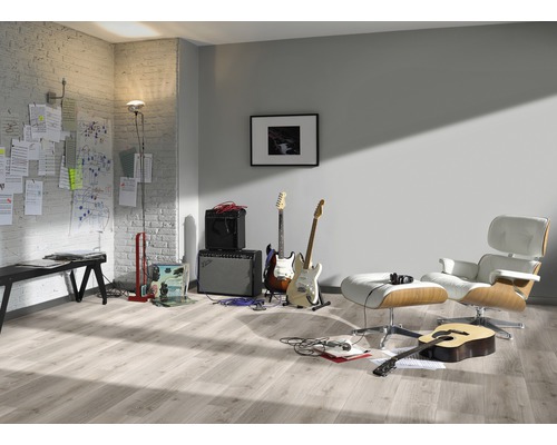 Heller Raum mit Gitarren, Verstärkern, Sessel und Laminatboden