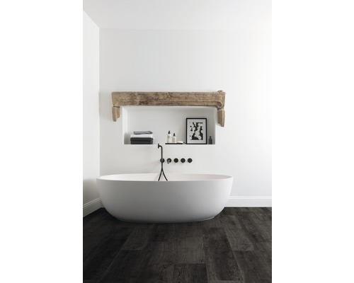 Freistehende Badewanne in einem Badezimmer mit Holzboden, Nische mit Dekorationen und Armaturen