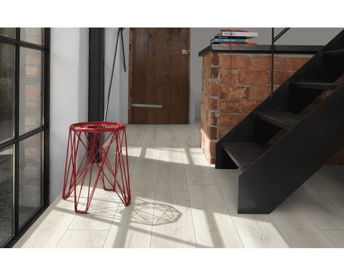 Helle Diele mit rotem Hocker, Treppe und Holztür