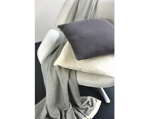 Sessel mit dekorativen Kissen und Überwurf