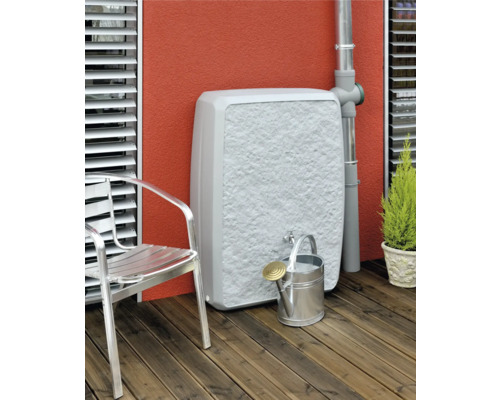 Wassertank mit Wasserhahn, Gießkanne und Gartenstuhl auf einer Terrasse