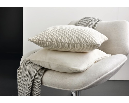 Dekorative Kissen und Decke auf einem Stuhl