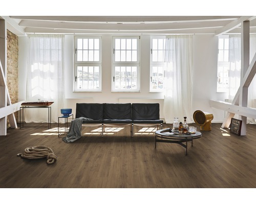 Heller Raum mit Laminatboden, Sofa und Fenstern