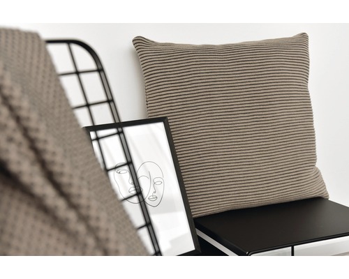 Dekokissen mit Streifenmuster auf Stuhl neben Bild im Rahmen und Überwurf