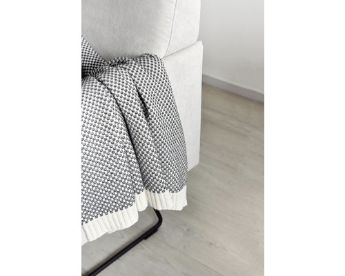 Detailansicht einer gemusterten Tagesdecke, die über einem Sofa drapiert ist