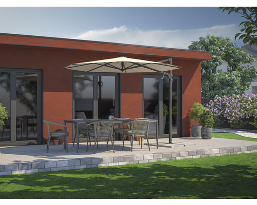 Terrasse mit Esstisch, Stühlen und Sonnenschirm vor einem Haus.