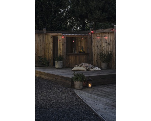 Holzterrasse mit Gartenmöbeln, Beleuchtung und Pflanzen