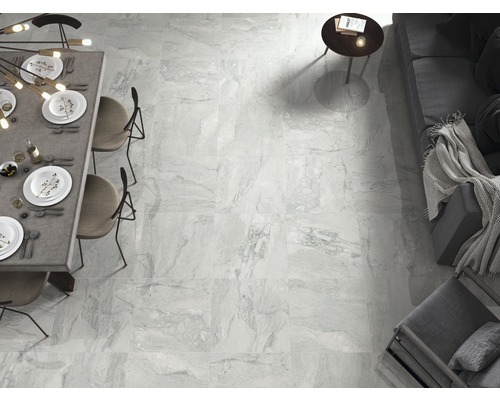 Helle, geflieste Wohnraumansicht mit Esstisch und Sitzgelegenheiten.