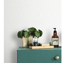 Dekorative Gegenstände auf einem grünen Badschrank vor einer hellen Tapete