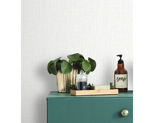 Dekorative Gegenstände auf einem grünen Badschrank vor einer hellen Tapete