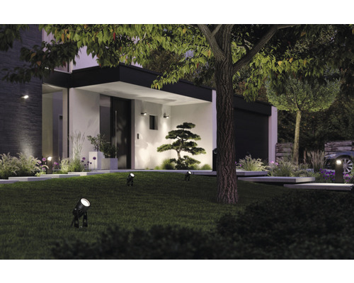 Beleuchteter Garten mit Rasenfläche, Bäumen und moderner Hausfassade