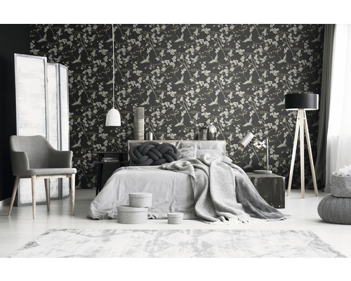 Schlafzimmer mit floraler Tapete, Bett, Stuhl und Lampen