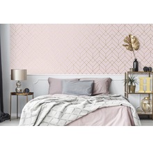 Schlafzimmer mit Bett und geometrischer Tapete in Rosa und Gold