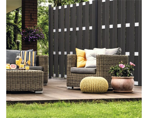 Terrasse mit Flechtmöbeln und Sichtschutzzaun