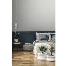 Schlafzimmer mit Bett, Nachttisch, Lampe, Pflanzen und Tapete