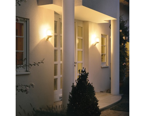 Beleuchtete Hausfassade mit zwei runden Wandleuchten