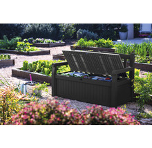 Geöffnete Gartenbankbox im Garten mit Gartengeräten.
