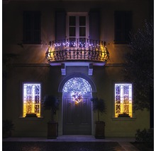 Hausfassade mit weihnachtlicher Beleuchtung an Balkon, Fenstern und Tür