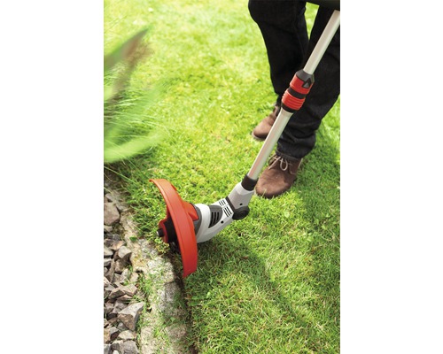 Rasentrimmer im Einsatz zum Kantenschneiden eines Rasens