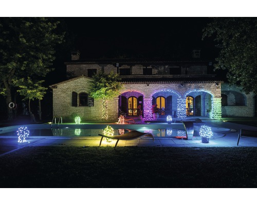 Illuminiertes Haus mit Pool und Lichterketten bei Nacht