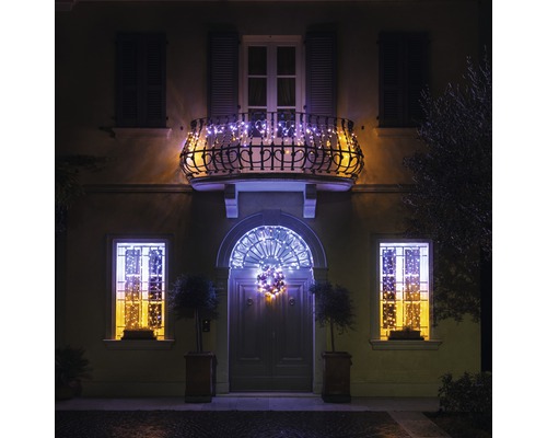 Hausfassade mit Fenster, Balkon und Haustür, dekoriert mit Lichterketten für Weihnachten