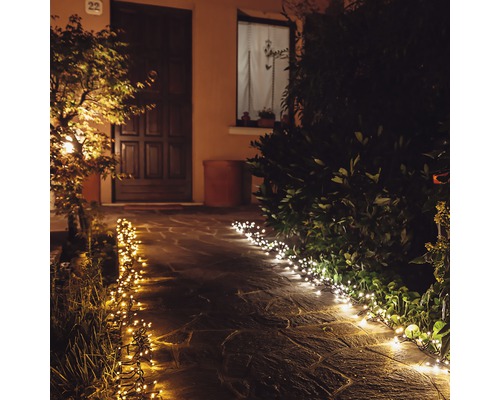 Beleuchteter Gartenweg mit Lichterketten für eine stimmungsvolle Atmosphäre.