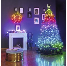 Weihnachtliche Wohnraumdekoration mit beleuchtetem Kranz, beleuchtetem Weihnachtsbaum und Kamin