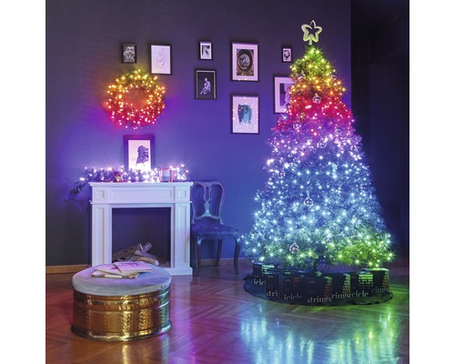 Weihnachtliche Wohnraumdekoration mit beleuchtetem Kranz, beleuchtetem Weihnachtsbaum und Kamin