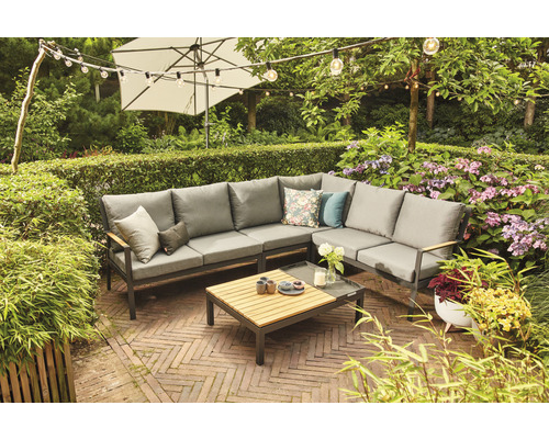 Gartenmöbel-Set mit Ecksofa, Tisch und Sonnenschirm in üppiger Gartenszene