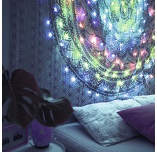 Schlafzimmer mit Wandteppich und Lichterkette über dem Bett