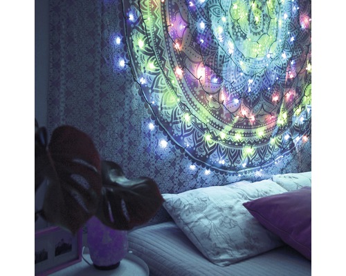 Schlafzimmer mit Wandteppich und Lichterkette über dem Bett