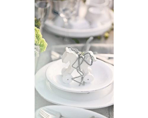 Dekorativer Tisch mit Holzpferd auf Teller