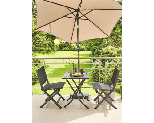 Gartenszene mit Gartentisch, zwei Stühlen und Sonnenschirm auf einem Balkon