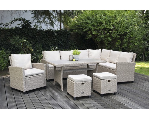 Gartensitzgruppe mit Tisch, Eckbank, Sessel und Hockern auf einer Terrasse vor einer grünen Hecke.