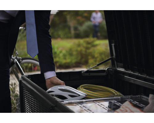 Geöffneter Fahrradanhänger mit Fahrradhelm und Kabel