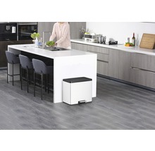 Moderne Küche mit Kücheninsel, Barhockern und einem Abfalleimer mit Pedal